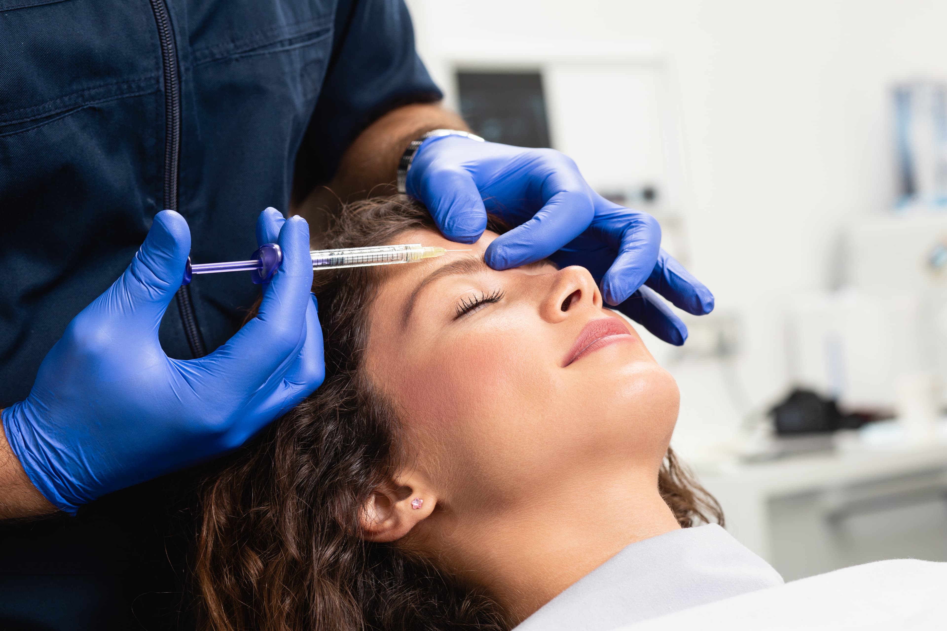 A provider injecting Botox® near a patient's brow