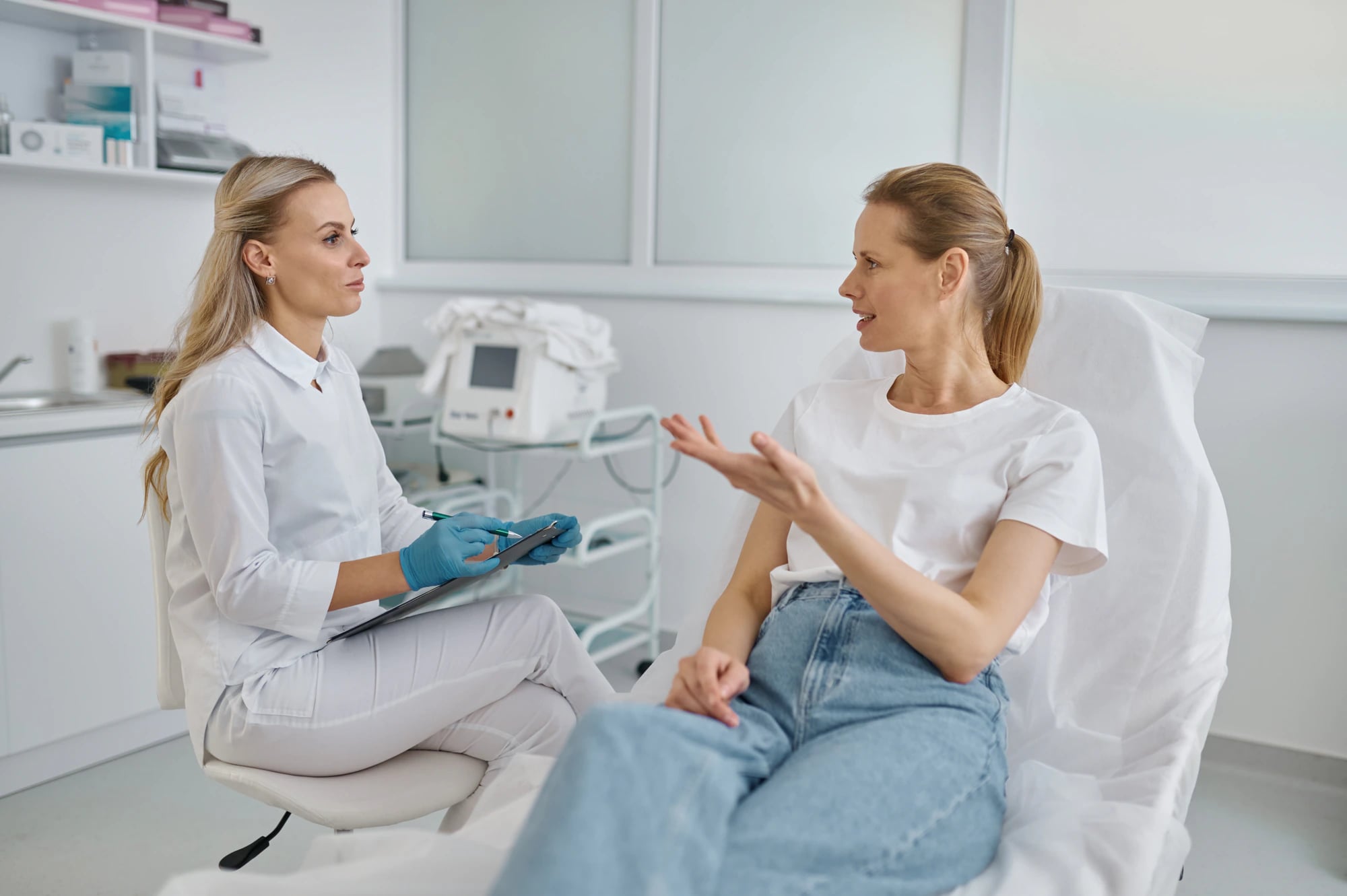 A provider and a client talking through a treatment plan in a treatment room.